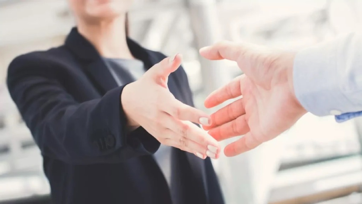 Due persone che si stringono la mano davanti a un punto vendita